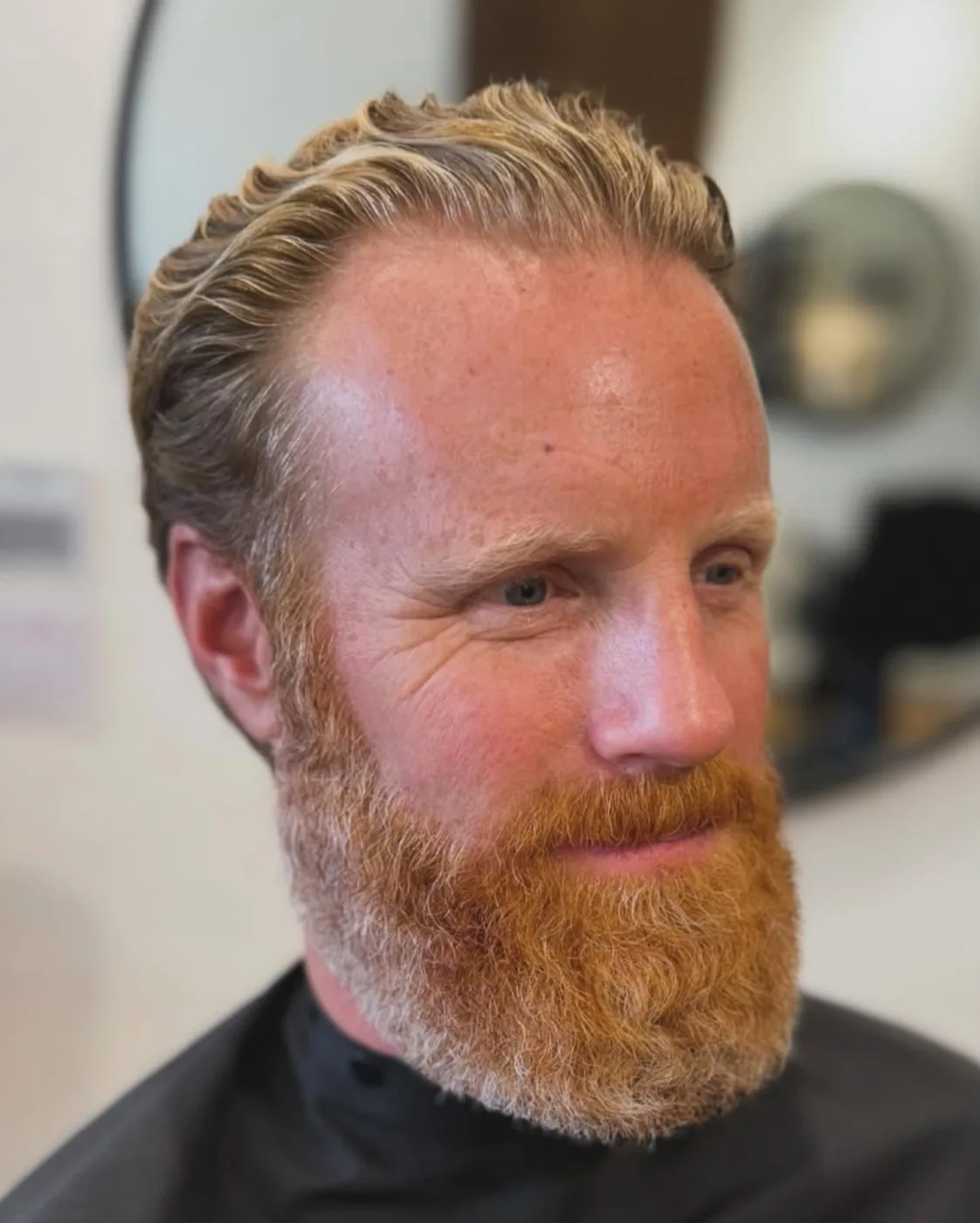 Finished men's haircut — wavy tapered cut, younger client